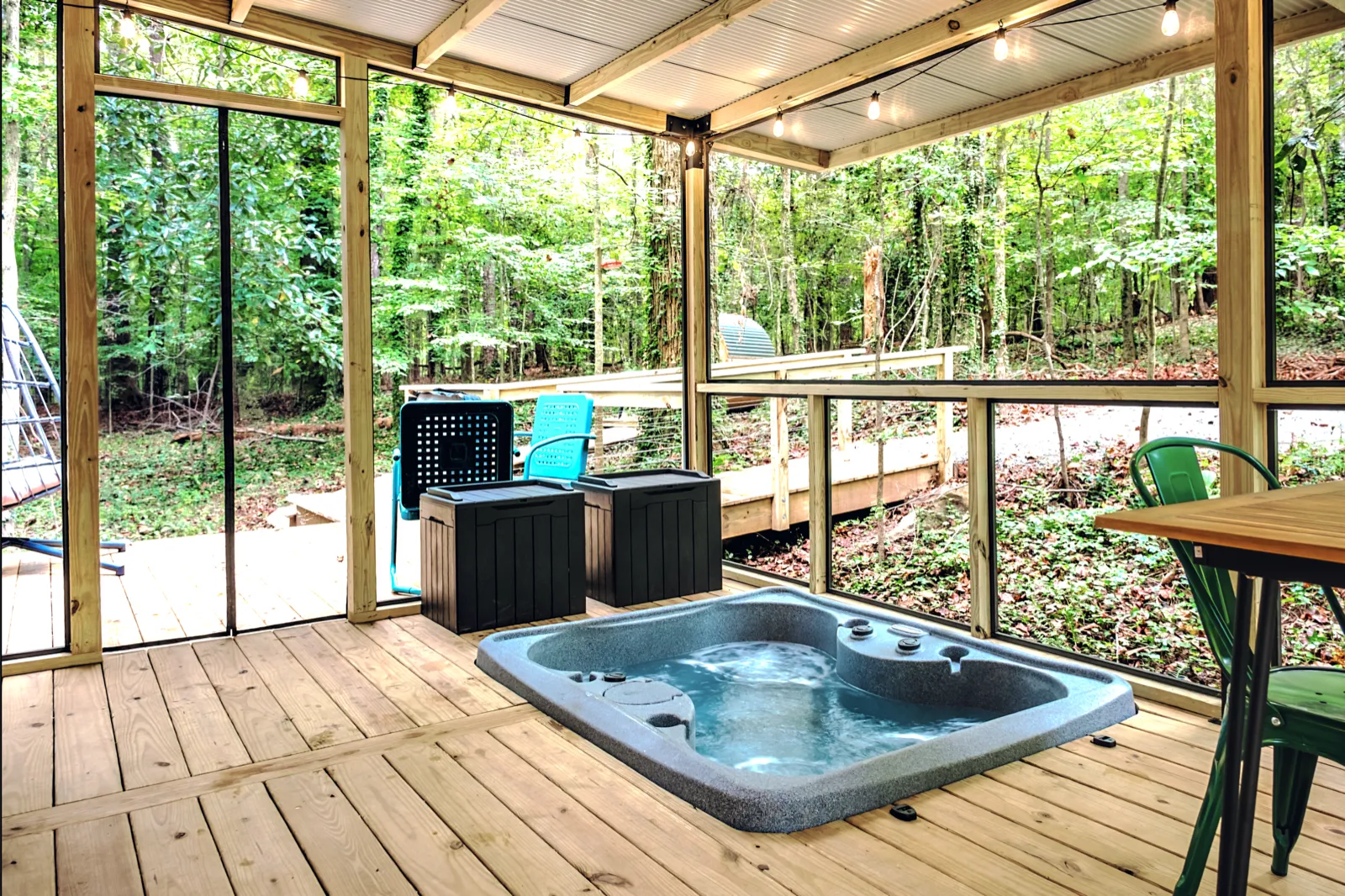 Sunken hot tub on the screened porch deck surrounded by forest views